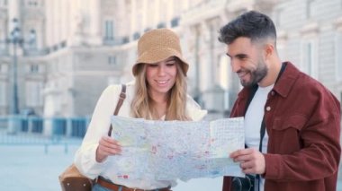 Genç beyaz çift İspanya, Madrid 'i ziyaret etmek için bir tur hazırlamak için haritayı kontrol ediyor..