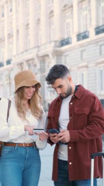 İspanya, Madrid 'i ziyaret etmek için kredi kartı ve telefonla tur biletleri alan genç beyaz bir çift..