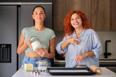 Anne ve kızı bir kurabiye tarifini işaret diliyle açıklıyor. Un işareti.