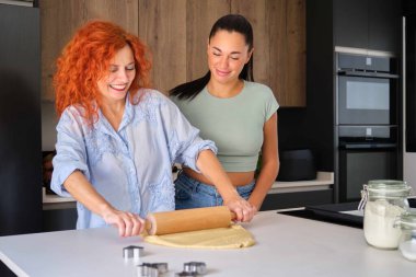 Mutlu anne ve kız birlikte tereyağlı kurabiye hazırlıyorlar. Aile zamanı..