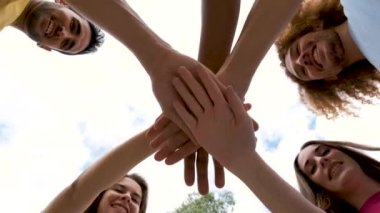 Sokakta el ele tutuşan çok ırklı genç arkadaşların düşük açılı görüntüsü.