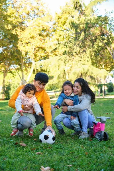 2人の子供のサッカーボールと公園のバランスバイクを持つラテンファミリー ヒスパニック系 — ストック写真