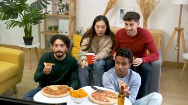 Bir grup arkadaş pizza yiyor ve futbol takımının golünü paylaşılan bir öğrenci evinde kutluyorlar..