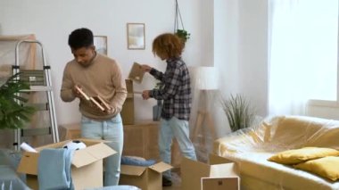 İki adam yeni bir eve yerleşmek için hareket eden bir karton kutuda toplanıyor. Öğrenci ikametgahı.