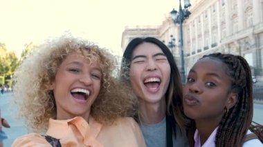 Üç çok ırklı mutlu arkadaş yazın Madrid, İspanya 'da selfie çekip gülüyorlar..