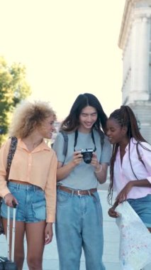 İspanya, Madrid 'i gezerken kamerayla fotoğraflara bakan üç çok ırklı arkadaş..