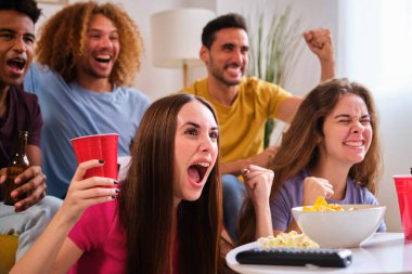 Genç arkadaşlar, futbol takımları için tezahürat yapan bir golü kutluyorlar..