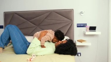 Kübalı anne, küçük kızıyla yatak odasında oynuyor..