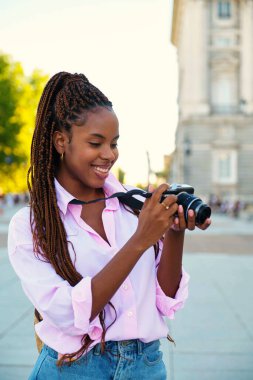 Kübalı bayan turist Madrid, İspanya 'yı gezerken gülümsüyor ve fotoğraf çekiyor..