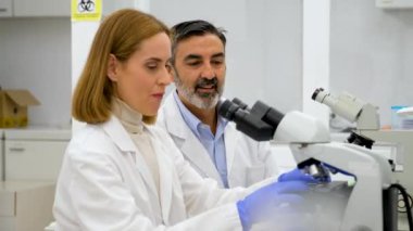 Bilim adamı mikroskoptan bakıp bir şey keşfetmek ve bir biyokimya laboratuvarında çalışmak için heyecanlı. Bilim araştırması.