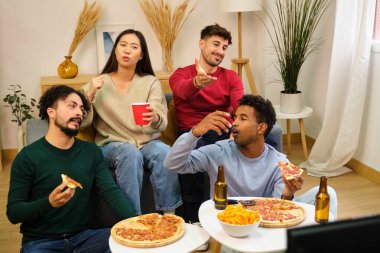 Bir grup arkadaş, aynı öğrenci evinde futbol takımının hatası yüzünden pizza yiyorlar..