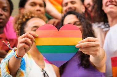 Uluslararası Onur Ayı 'nı kutlayan bir grup LGBTQ' lu ellerinde gökkuşağı kalbi tutuyor..