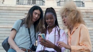 İspanya, Madrid 'i gezerken telefonda tarihi yerleri arayan üç çok ırklı arkadaş..