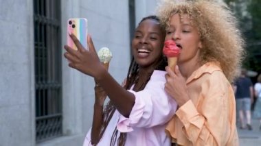 Dondurmalı iki çok ırklı arkadaş yazın sokakta selfie çekiyor..