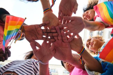 Gökkuşağı LGBTQ bilezikleri takan bir grup çok ırklı insan. Sahne, LGBTQ topluluğu için birlik ve desteklerden biridir..