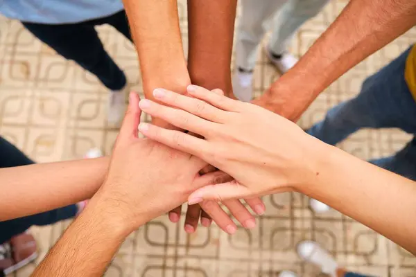 Sokakta el ele tutuşan çok ırklı arkadaşların yüksek açılı görüntüsü.