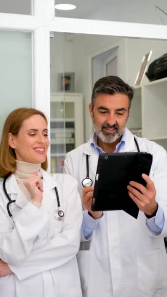Dwóch Profesjonalnych Lekarzy Rozmawiających Raportach Medycznych Korzystających Tabletu Biurze — Wideo stockowe