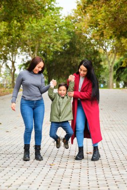 Kolombiyalı lezbiyen çift parkta oğluyla oynuyor. LGBT Ailesi.