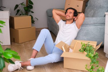 Genç adam yeni dairesine taşındıktan sonra bavullarını boşaltmaya ara verdi.