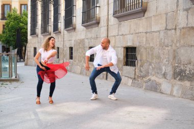 İki dansçı bir şehir caddesinde Küba dansı koreografisi yapıyor.