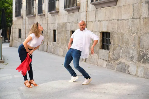 Genç İspanyol dansçılar eski bir Avrupa şehrinde Küba salsası yapıyorlar.