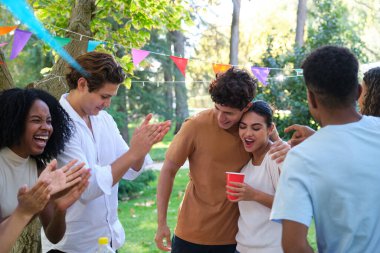 Bir grup arkadaş açık hava partisinde eğleniyor, kutlama yapıyor ve bir çifti kutluyorlar.