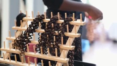 Afro kuaförde örgü örmek için saç eklentisini hazırlayan tanınmamış bir kuaför.