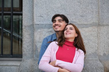 Şehirde sevgi ve umutla kucaklaşan mutlu çift.