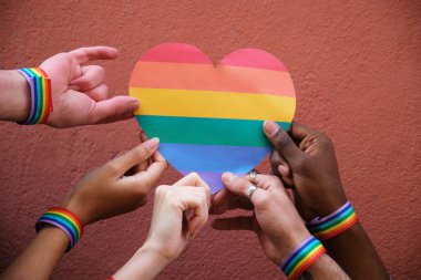 Eller gökkuşağının kalbini tutuyor, LGBT gururunu kutluyor ve çeşitliliği ve kapsamı destekliyor.