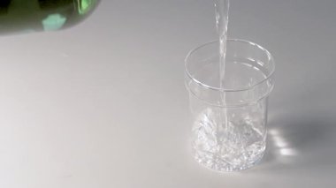 Beyaz arka planda bardağa su dökmek. Yavaş Hareket.