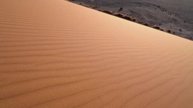 Kum, Afrika 'daki Namibya' daki Namib çölünde, Kum 45 'te rüzgarlı bir günde koşuyor..