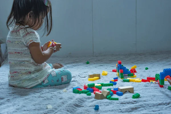 アジアの女性がプラスチックブロックから家を作る幼稚園の子供たちの開発を促進するという概念 — ストック写真