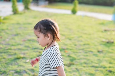 Gün batımında, oldukça uzun saçlı bir kızın, temiz havada yürümek için dikey portresi.