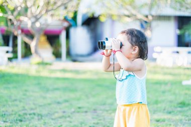 Güneşli bir günde ulusal parktaki dürbünle bakan güzel bir genç kadın..