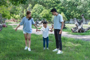 Parkta birlikte oynayan Asyalı genç bir ailenin görüntüsü