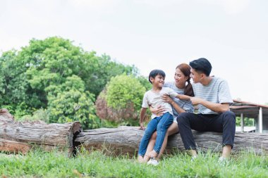 Parkta birlikte oynayan Asyalı genç bir ailenin görüntüsü