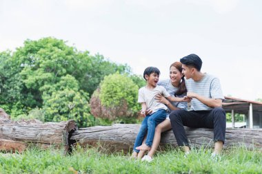 Parkta birlikte oynayan Asyalı genç bir ailenin görüntüsü