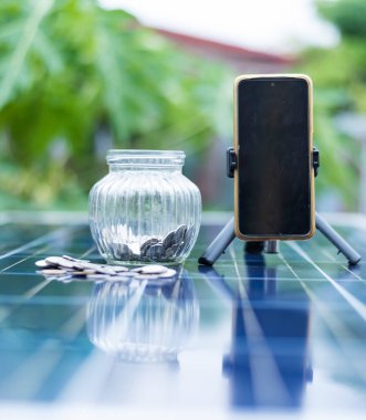 Bozuk para ve bulanık güneş paneli hücresi arka planda fotokopi uzayı ile. Yenilenebilir enerji kaynakları kavramında para işi.