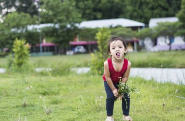 Daha güzel buketi olan neşeli bir çocuk. Doğada gülümseyen küçük çocuk, anneler günü, aşk ve romantizm..