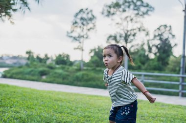 Dışarıda oynayan mutlu çocuklar yaz tatilinde güneş ışığıyla bahçeye atlayıp oyun bahçesinde sağlıklı açık hava aktiviteleri yapan çocuklar. Çocuklar için spor..