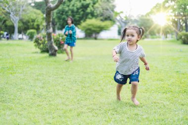 Mutlu Güneydoğu Asyalı kızlar bahar parkında oynuyorlar. Asyalı çocuklar bahçede oynuyor Yaz tatili.