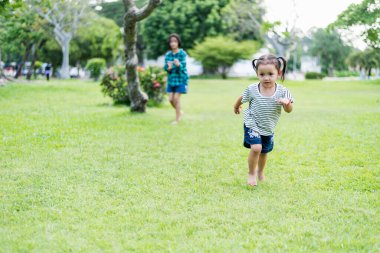 Mutlu Güneydoğu Asyalı kızlar bahar parkında oynuyorlar. Asyalı çocuklar bahçede oynuyor Yaz tatili.