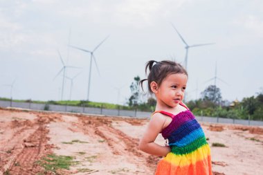 Asyalı kızlar elektrik üretmek için rüzgar türbinlerini incelerler. Sürdürülebilir enerji. gelecek.