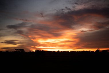 Parlayan altın, portakal kırmızısı, bulutlu gökyüzü gün batımında. Duvar kağıdı kavramı.