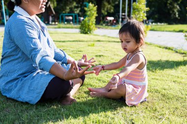 Gün batımında meditasyon yapan Asyalı bir kadının el yordamıyla yoga dersi ve özel sağlık hizmetleri, fitness yaşam tarzı konsepti ve yoga sporları ayı..