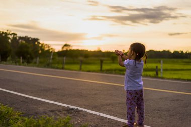 Sağlıklı bir kız güzel bir gün batımında kutlama yapıyor..