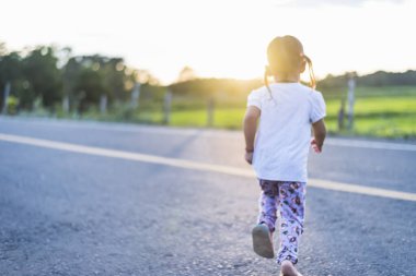 Yazın dağlarda yükselen güneşe doğru yürüyen çocuk siluetleri, sağlıklı aile tatili, rüya ve mutlu çocukluk, sonsuz yaz tatili, güzel yaz manzarası, altın renkleri