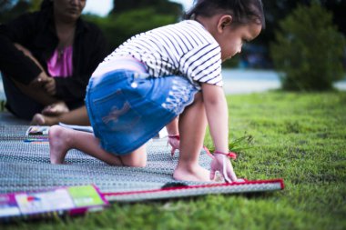 Parkta koşan bir kız çocukların hayali tatil konsepti, mutlu bir aile. Güneşin altında koşuşturmak.