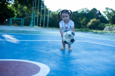 Futbol oynayan şirin bir çocuk. Çocuklar açık alanda oynuyorlar. Sevimli küçük atlet topa vuruyor Yaz sporları Aktif çocuklar için Çocuklar spor yapıyor.