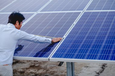 Kadın elektrik mühendisliği ekibi güneş fotovoltaik panellerini kurup inceliyor. Temiz ve çevre dostu alternatif enerji.